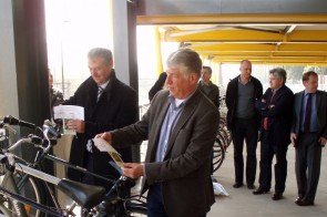 burgemeester & directeur hangen zaadzakjes aan fietsen